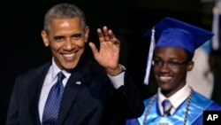 El presidente Barack Obama, acompañado de un graduando, saluda a su llegada a la ceremonia de graduación de la escuela Worcester Technical High School, en Massachusetts.