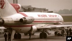 Des policiers français encadrent les passagers lors d’un contrôle des bagages sur le tarmac de l’aéroport de Roissy Charles de Gaulle, 26 avril 1997.