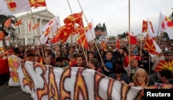 FILE - Protesters march through a street in Skopje, Macedonia, April 3, 2017.