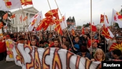 People protest marching through a street in Skopje, Macedonia, on April 3, 2017. 