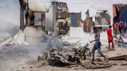 People sift through wreckage at the scene of a blast in Mogadishu, Somalia, Jan. 12, 2022.