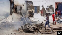 People sift through wreckage at the scene of a blast in Mogadishu, Somalia, Jan. 12, 2022.