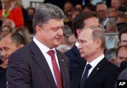 Ukraine's President-elect Petro Poroshenko, left, walks past Russian President Vladimir Putin during the commemoration of the 70th anniversary of the D-Day in Ouistreham, western France, June 6, 2014.
