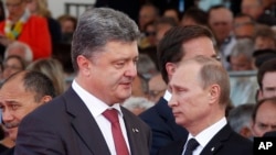 Ukraine's President-elect Petro Poroshenko, left, walks past Russian President Vladimir Putin during the commemoration of the 70th anniversary of the D-Day in Ouistreham, western France, June 6, 2014.