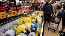 People shop for frozen turkeys for Thanksgiving dinner at a grocery store in Mount Prospect, Illinois, Nov. 17, 2021. 