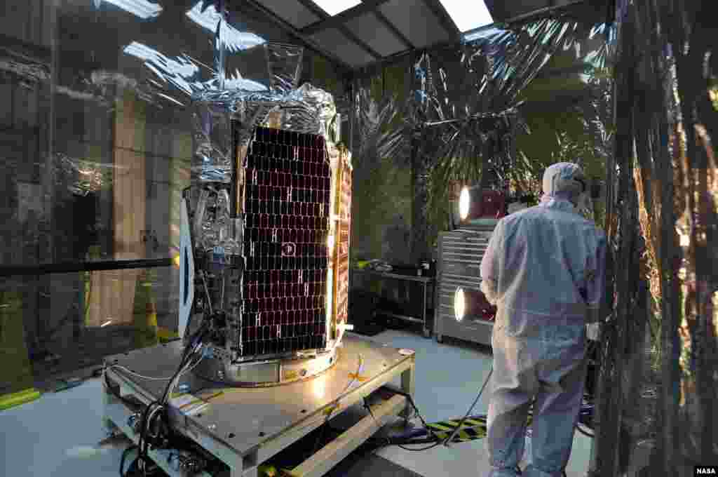 In a clean room at Vandenberg Air Force Base's processing facility in California, a technician conducts a solar array illumination test on NASA's NuSTAR spacecraft, February 2, 2012. (NASA)