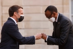 Presiden Prancis Emmanuel Macron (kiri) menyambut Presiden Rwanda Paul Kagame pada saat kedatangannya untuk makan malam di Istana Kepresidenan Elysee di Paris, pada 17 Mei 2021. (Foto: AFP/Ludovic Marin)