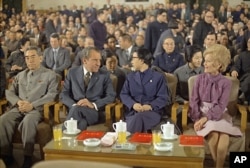 1972年2月28日，上海，中国总理周恩来和毛泽东夫人江青陪美国总统尼克松和夫人观看文艺演出。坐在江青后面的戴眼镜者是郭沫若。