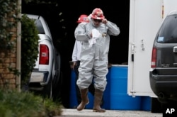 FILE - Environmental specialists disinfect the apartment of a health care worker who tested positive for Ebola in Dallas, Texas, Oct. 13, 2014.