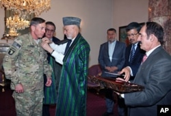 Le président afghan Hamid Karzai décorant le général Petraeus