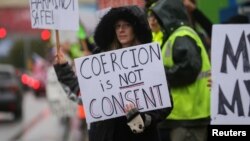 A woman who wishes to remain unnamed holds a sign as Boeing employees and others protest the company's coronavirus disease (COVID-19) vaccine mandate, outside the Boeing facility in Everett, Washington, October 15, 2021. REUTERS/Lindsey Wasson/File Photo