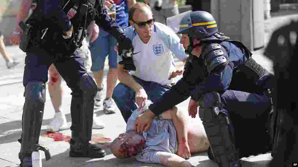 Un homme, blessé dans les affrontements, est assisté par des officiers à Marseille, le 11 juin 2016.