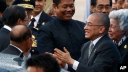 Cambodian King Norodom Sihamoni, second from left, accompanied by his Queen Mother Monineath, right, greets Prime Minister Hun Sen, left, upon arrival from Beijing at Phnom Penh International Airport, Cambodia, Wednesday, Sept. 11, 2013. Sihamoni returned home after spending a month-long stay in Beijing for a medical checkup. (AP Photo/Heng Sinith)