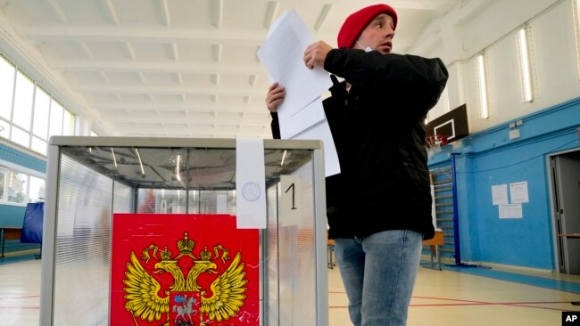 Genç bir seçmen St. Petersburg'da sandık başında