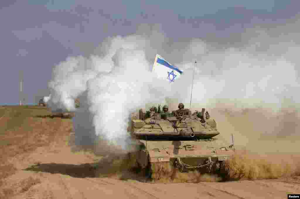 Seorang prajurit Israel memberikan tanda dari atas tank setelah melewati perbatasan kembali ke Israel. Israel menarik pasukan daratnya keluar dari Jalur Gaza di awal genjatan senjata selama 72 jam dengan Hamas, 5 Agustus 2014.