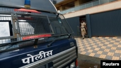 Policemen come out of one of the closed call centers in Mira-Bhayander, on the outskirts of Mumbai, India, Oct. 6, 2016.