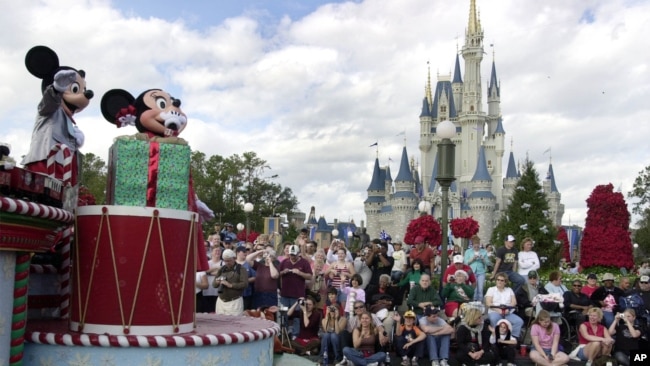 FILE - Visitors gather in front of Cinderella's castle to watch Mickey and Minnie Mouse during the Christmas parade at Walt Disney World's Magic Kingdom in Lake Buena Vista, Florida, Dec. 22, 2004.