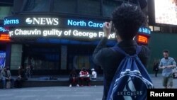 Mladić na Tajms Skveru fotografiše ekran sa vešću da je policajac Šovin proglašen krivim za ubistvo Džordža Flojda 20. aprila 2021.