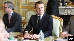 French President Emmanuel Macron flanked by Elysee general secretary Alexis Kohler, left, holds a meeting at the Elysee presidential Palace, in Paris, March 18, 2019. Macron summoned top security officials after police failed to contain rioting during recent yellow vest protests.