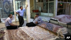 FILE - Iranian merchants wait for customers at a carpet market in Tehran's old main bazaar, in Iran, Aug. 10, 2015. Anger and frustration over the economy has been the main fuel for the surprise eruption of protests that began Dec. 28, 2017. 