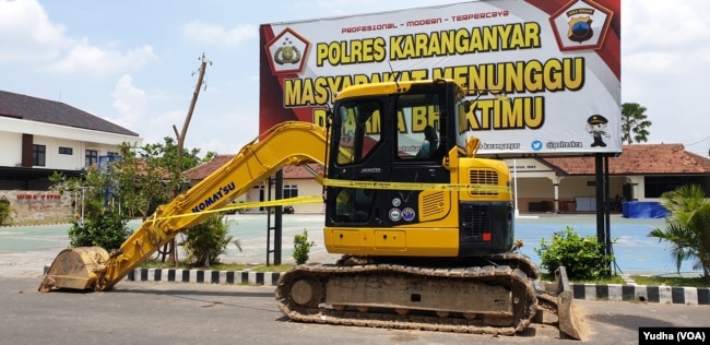Barang bukti ekskavator dari tersangka penebangan pepohonan di hutan Lereng Gunjng Lawu Karangnyar masih dipasangi garis polisi di Mapolres Karanganyar, Selasa, 21 Januari 2020. (Foto: VOA/Yudha)