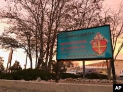 The sun sets on a sign in front of the Archdiocese of Santa Fe offices in Albuquerque, N.M., Nov. 29, 2018. Archbishop John Wester announced Thursday that the archdiocese will be filing for Chapter 11 bankruptcy protection, as the Catholic church in New Mexico has settled numerous claims of sexual abuse by clergy over the years and is close to depleting its reserves.