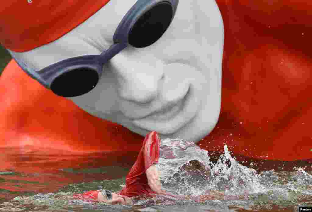 A swimmer passes a temporary floating sculpture on the Serpentine Lake at Hyde Park in London, Sept. 11, 2013.