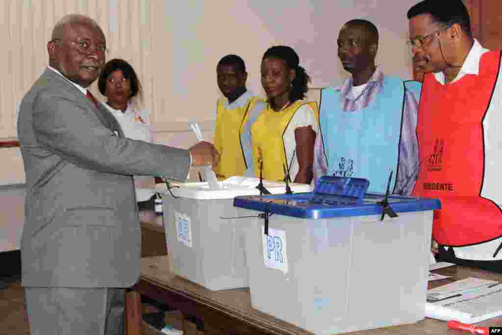 Incumbent Mozambican president Armando Guebuza (L) casts his ballot to vote in the general elections at a polling station in Maputo.