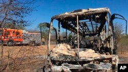 FILE: A fire engine is parked near to a burnt out bus after a fatal bus accident in Gwanda, south of the capital Harare, Zimbabwe, that killed more than 40 people, Nov. 16, 2018. 