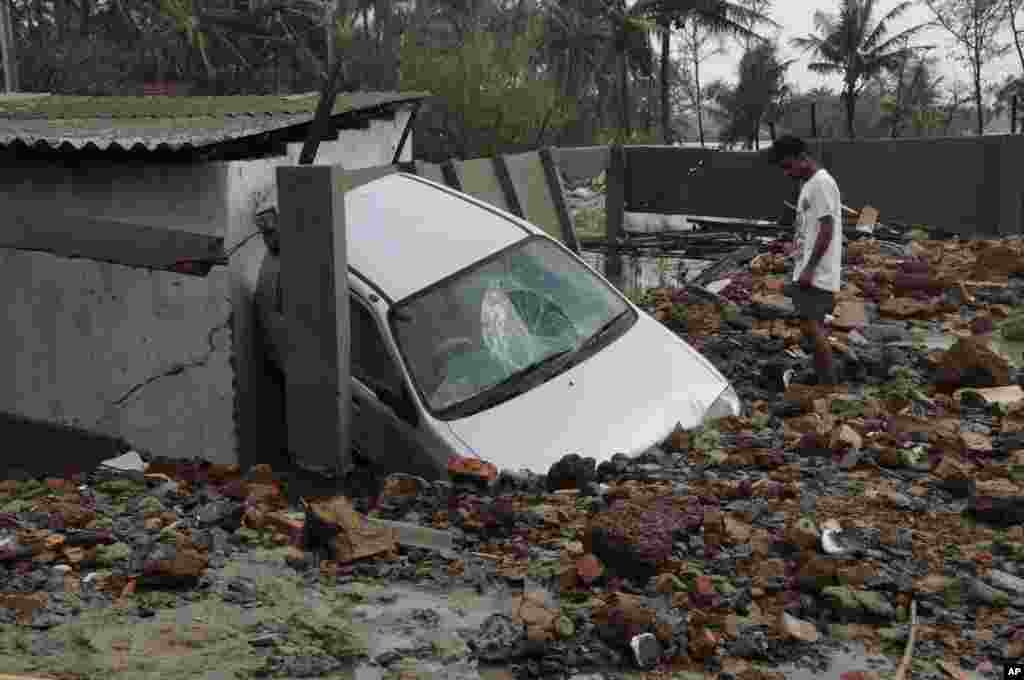 Seorang pria melihat sebuah mobil rusak akibat Topan Yaas yang melanda Digha di pantai Teluk Benggala, negara bagian Benggala Barat, India, Kamis 27 Mei 2021. (Foto: AP)&nbsp;