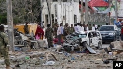 Security forces secure the scene next to destroyed vehicles following a suicide car bomb attack in the capital Mogadishu, Somalia, July 26, 2015.