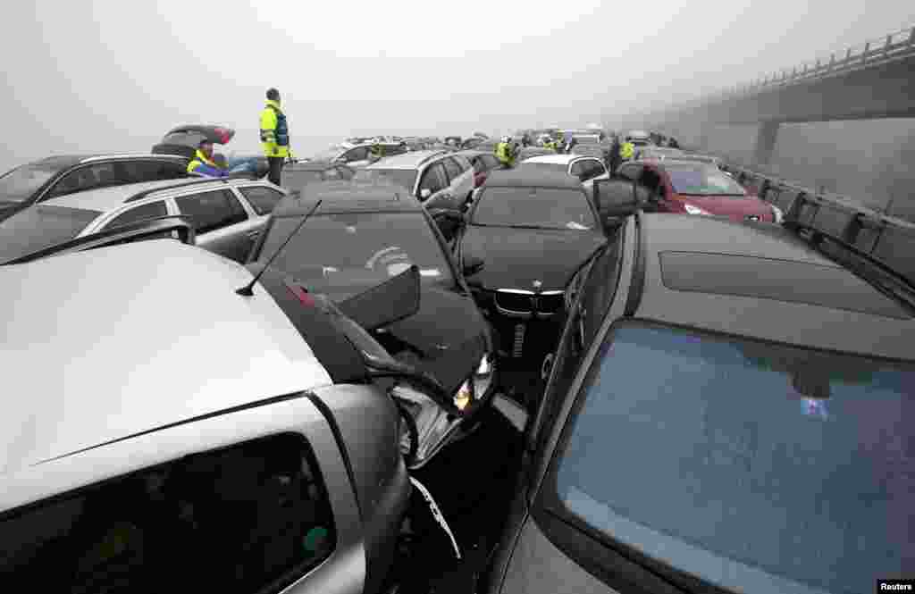 A first aid worker stands on a car at the site of a pileup on the A9 motorway near Chexbres, Switzerland. About 50 cars were involved in the pileup but no one was seriously injured, according to local media.