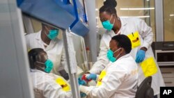 Medical scientists Melva Mlambo, right, and Puseletso Lesofi prepare to sequence COVID-19 omicron samples at the Ndlovu Research Center in Elandsdoorn, South Africa, Dec. 8, 2021.