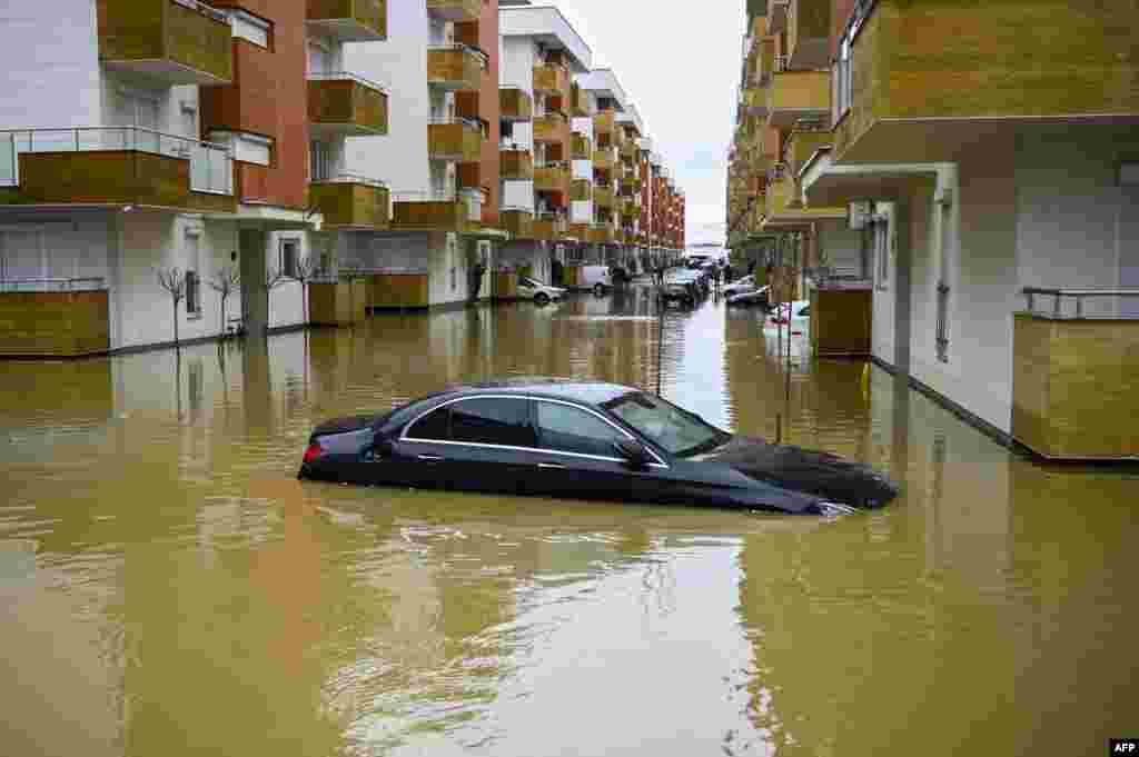 A car submerged on a flooded street in the town of Fushe Kosove after heavy rain and snow showers in Kosovo.