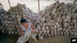 Tư liệu- Một người đàn ông lau sọ người gần một ngôi mộ tập thể tại Trại tra tấn Chaung Ek của chế độ Khmer Đỏ.