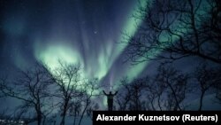 Um homem aprecia a aurora no céu de Kilpisjarvi, Finlândia. 18 de fevereiro, 2020