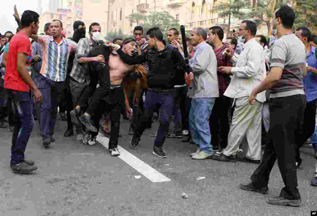 Egyptian security forces and civilians detain a supporter of ousted Egyptian President Mohamed Morsi near Ramsis Square, Cairo, Oct. 6, 2013.