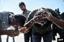 Migrants wash themselves after gathering in Edirne on the way to the Turkey-Greece border on Sept.16, 2015.