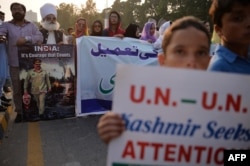 Pakistani Kashmiris carry placards to show their solidarity with Indian Kashmiri Muslims during an anti-Indian protest in Islamabad on Sept. 26, 2016.