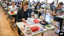 FILE - In this April 18, 2018 file photo students take a look at an exam test at the Graf-Zeppelin-Gymnasium in Friedrichshafen, Germany. 