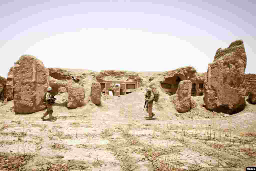 U.S. Navy Hospital Corpsman 1st Class William Neason, left, and U.S. Marine Corps 1st Lt. Stephen T. Desmond, both with the Georgian Liaison Team 9, patrol through the ruins of a 200 year-old castle during Operation Northern Lion in Mohammadabad, Helmand province, Afghanistan.&nbsp; Northern Lion was a Georgian-led Operation conducted to deter insurgents, establish a security presence and gather human intelligence in the area. (U.S. Marine Corps photo by Staff Sgt. Ezekiel R. Kitandwe)