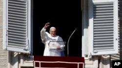Pope Francis waves as he arrives to recite the Angelus noon prayer from the window of his studio overlooking St.Peter's Square, at the Vatican, Nov. 11, 2018.