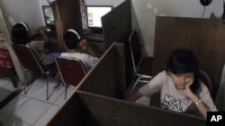 FILE - Indonesian youths browse at an internet cafe in Jakarta, Indonesia. (AP Photo/Tatan Syuflana)