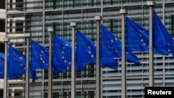 FILE - European Union flags are seen outside the European Commission headquarters in Brussels, Sept. 10, 2014. 