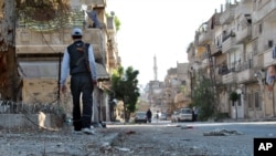 A Syrian rebel walks in Khaldiyeh neighborhood, Homs province, May 15, 2012.