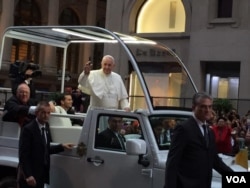 Pope Francis waves to huge crowds gathered in Manhattan as his motorcade drives along Fifth Avenue in New York, Sept. 24, 2015. (C. Presutti / VOA)