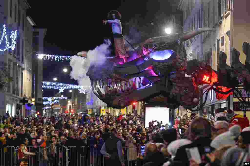 A member of the Compagnie Planete Vapeur standing on a giant animal skull performs during the parade of the festivities of Saint Nicholas in Nancy, eastern France, Dec. 1, 2018.