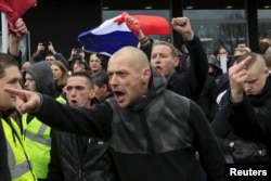 Activists against migrants shout slogans as they participate in a protest organized by the anti-Islam group Pegida in Calais, France, Feb. 6, 2016.