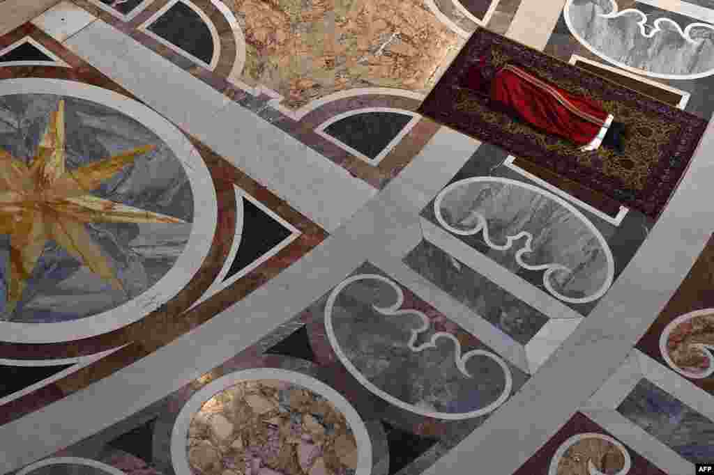 Pope Francis prays face down, on the floor of the Vatican's St. Peter's Basilica during the Celebration of Lord's Passion on Good Friday, April 3, 2015.
