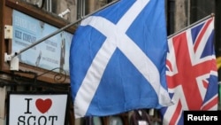 FILE - The Scottish Saltire flag (L) and the British Union flag are seen outside a shop in the centre of Edinburgh, Scotland on Sept. 12, 2014. 